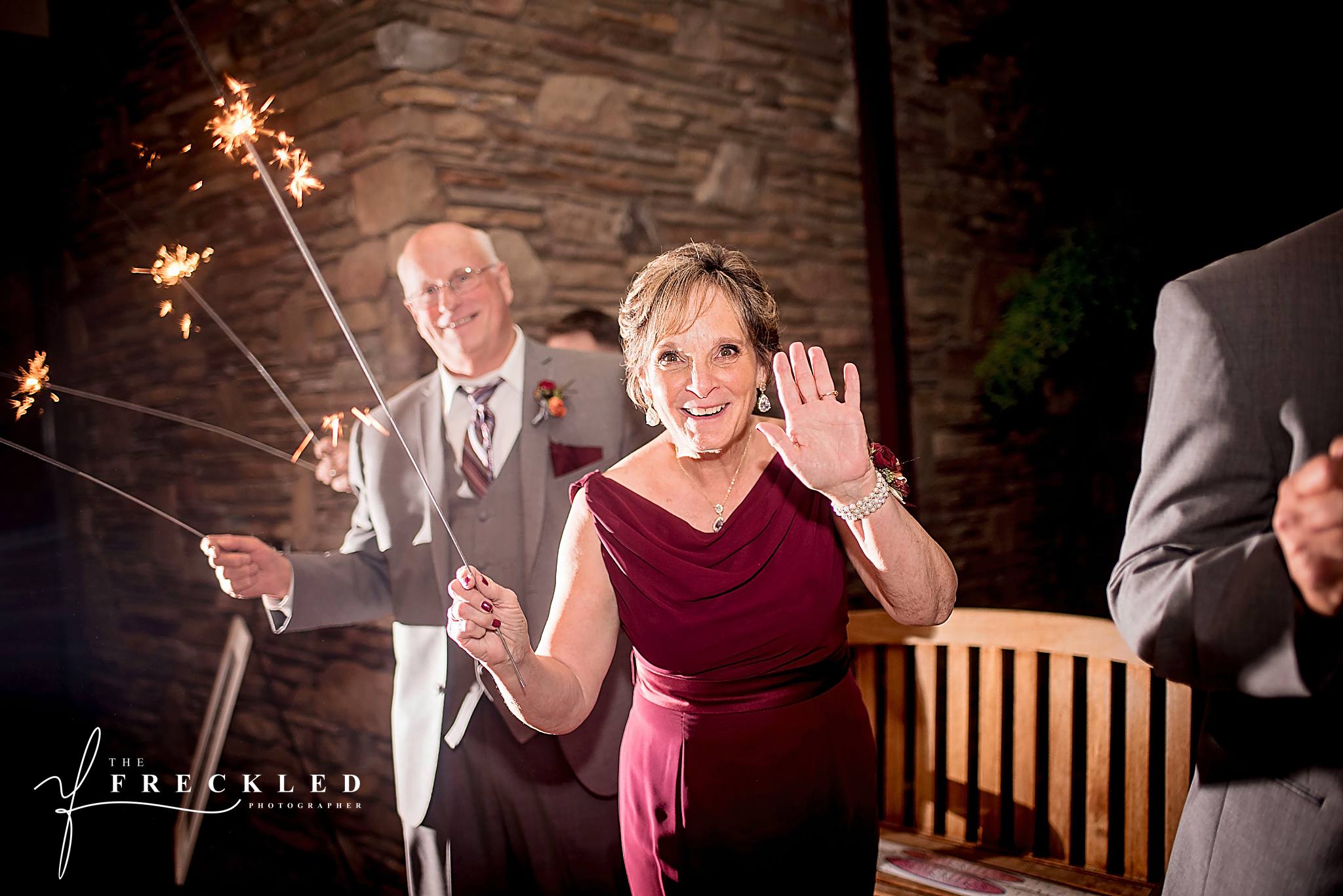 wedding guests waves sparkler at the camera during the sparkler exit