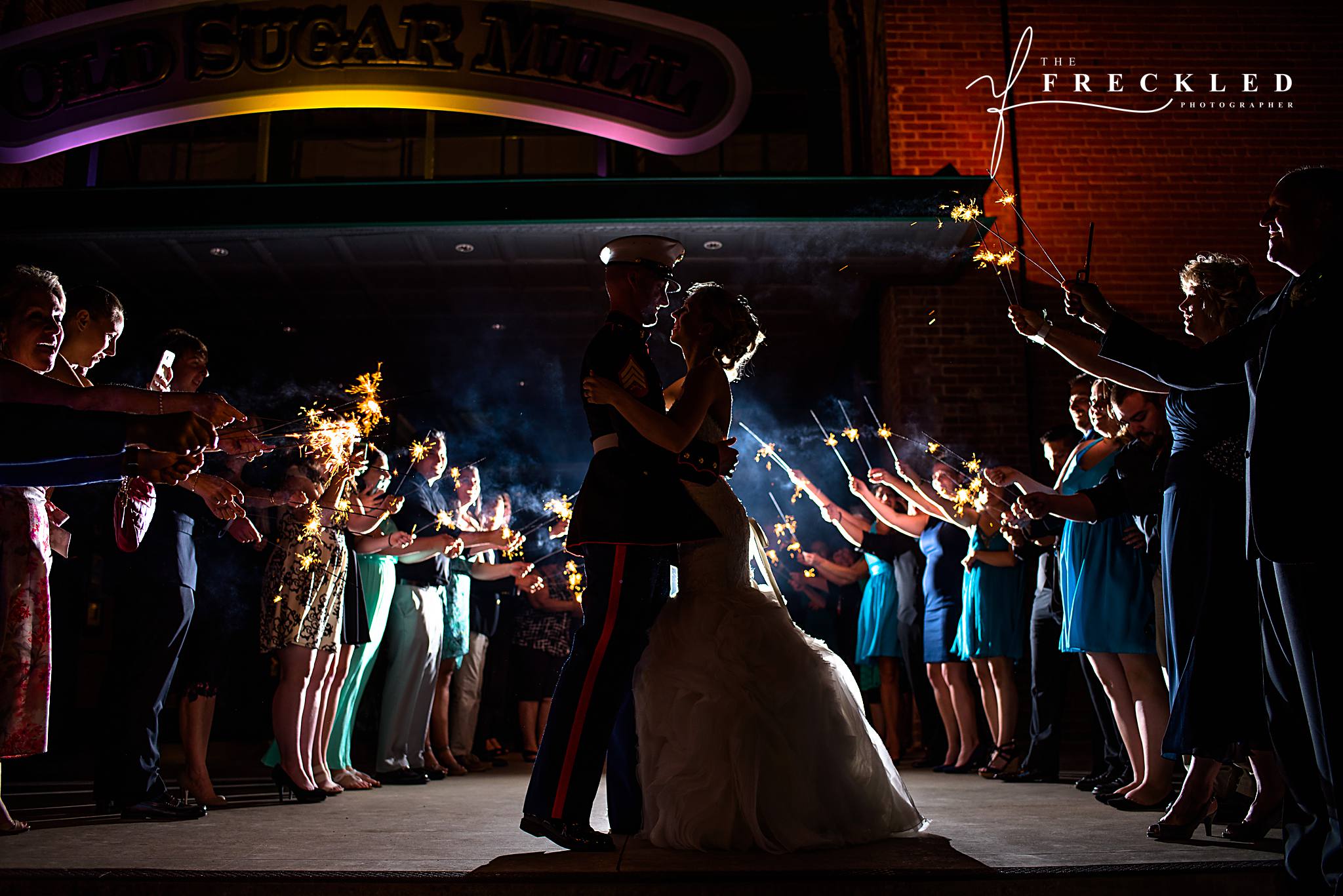 bride and groom in dramatic embrace during their wedding sparkler exit