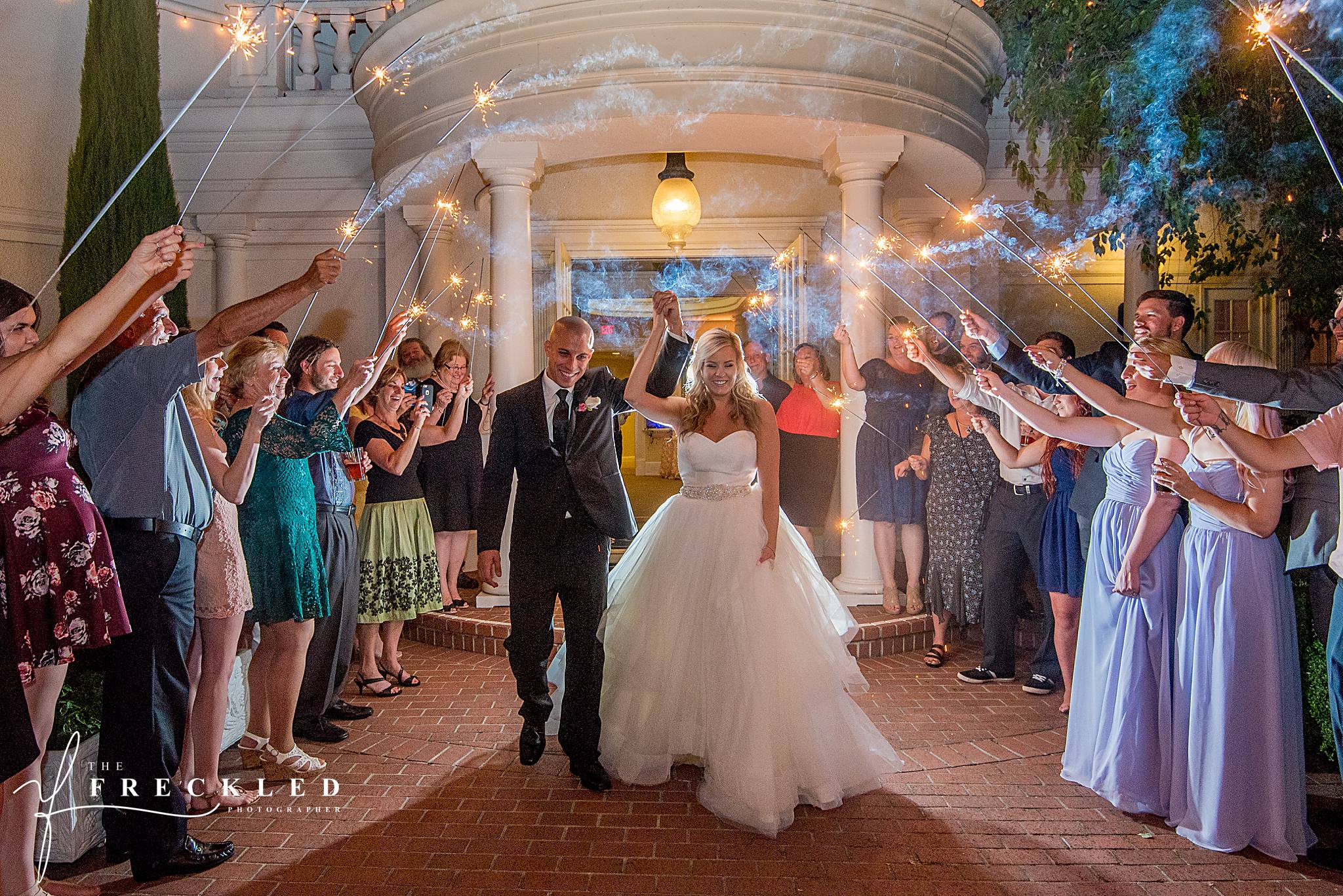 bride and groom exit Vizcaya wedding venue as guests hold wedding sparklers